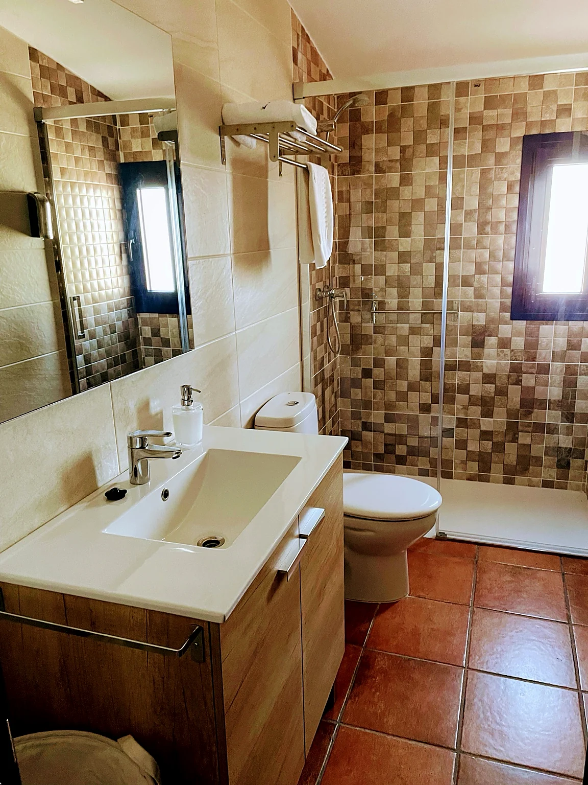 Modern renovated bathroom with walk-in rain shower and mosaic tiles at Masia St Salvador 1582