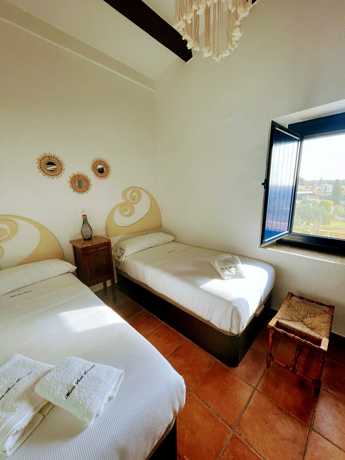 Twin bedroom with boho decor, open window and sea views at Masia St Salvador 1582 near Sitges