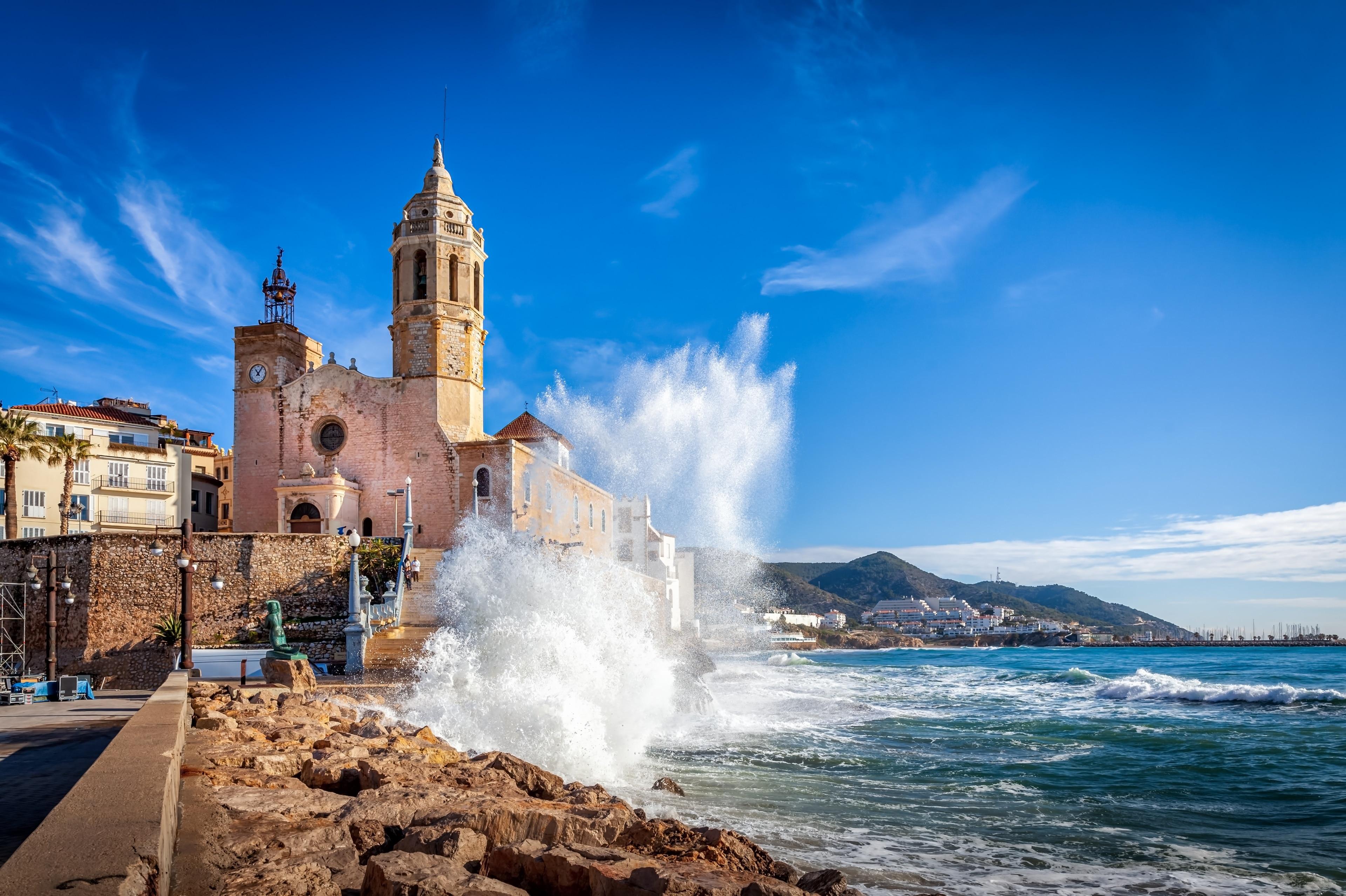 Church of Sant Bartomeu i Santa Tecla in Sitges with Mediterranean waves crashing on rocks, 15 minutes from Masia St Salvador 1582